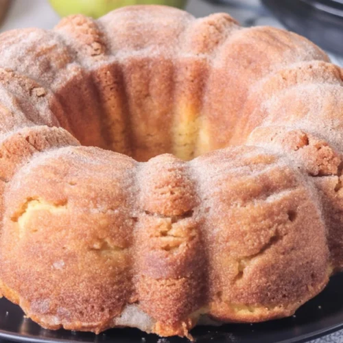 Cozy Up with This Irresistible Apple Cider Donut Cake 4 Moist Apple Cider Donut Cake topped with cinnamon sugar, perfect for fall treats.