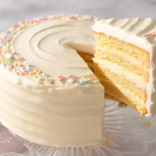 Simple and Delicious Vanilla Cake Recipes You’ll Love! 4 A slice of moist vanilla cake topped with creamy vanilla frosting on a plate.